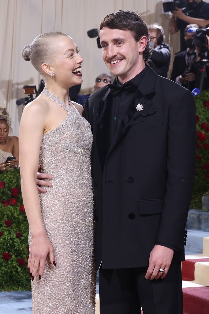 Paul Mescal in a black suit with his arm around Phoebe Bridgers in a sequin dress