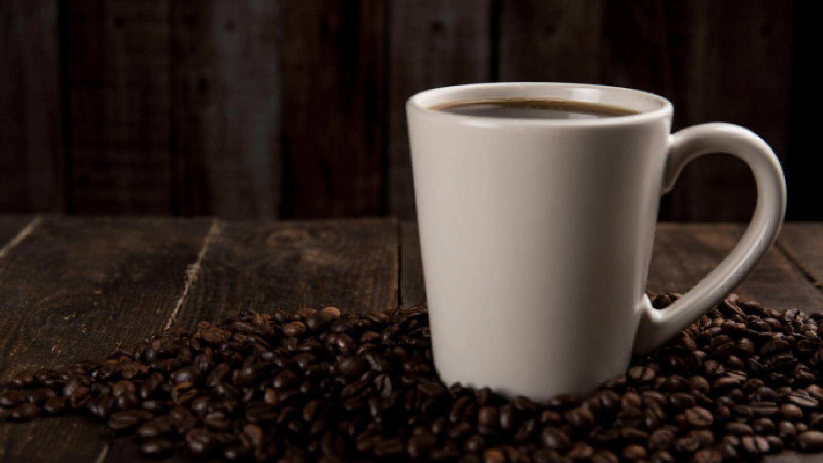 A mug of coffee with beans.