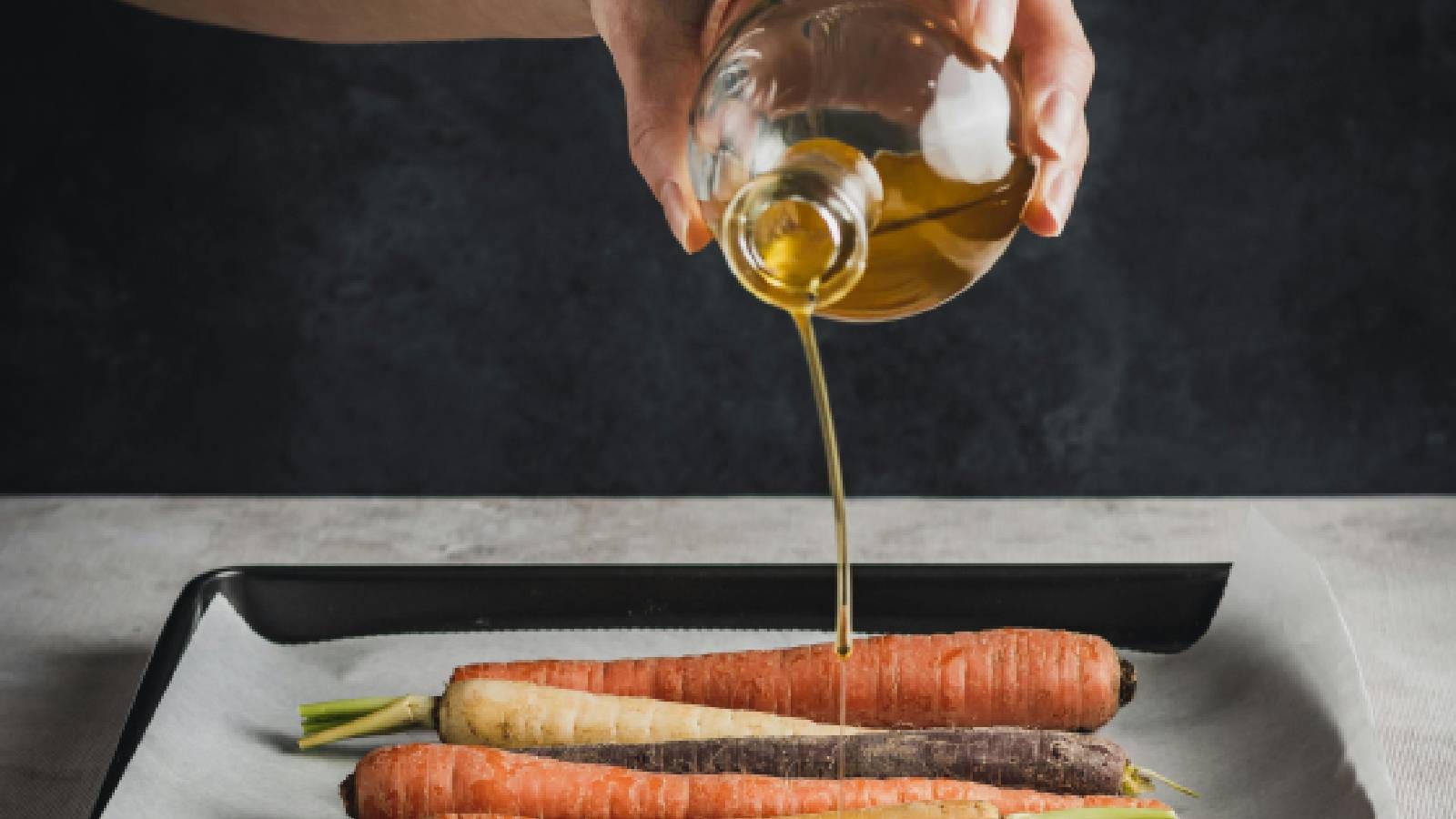 Oil being drizzled over carrots