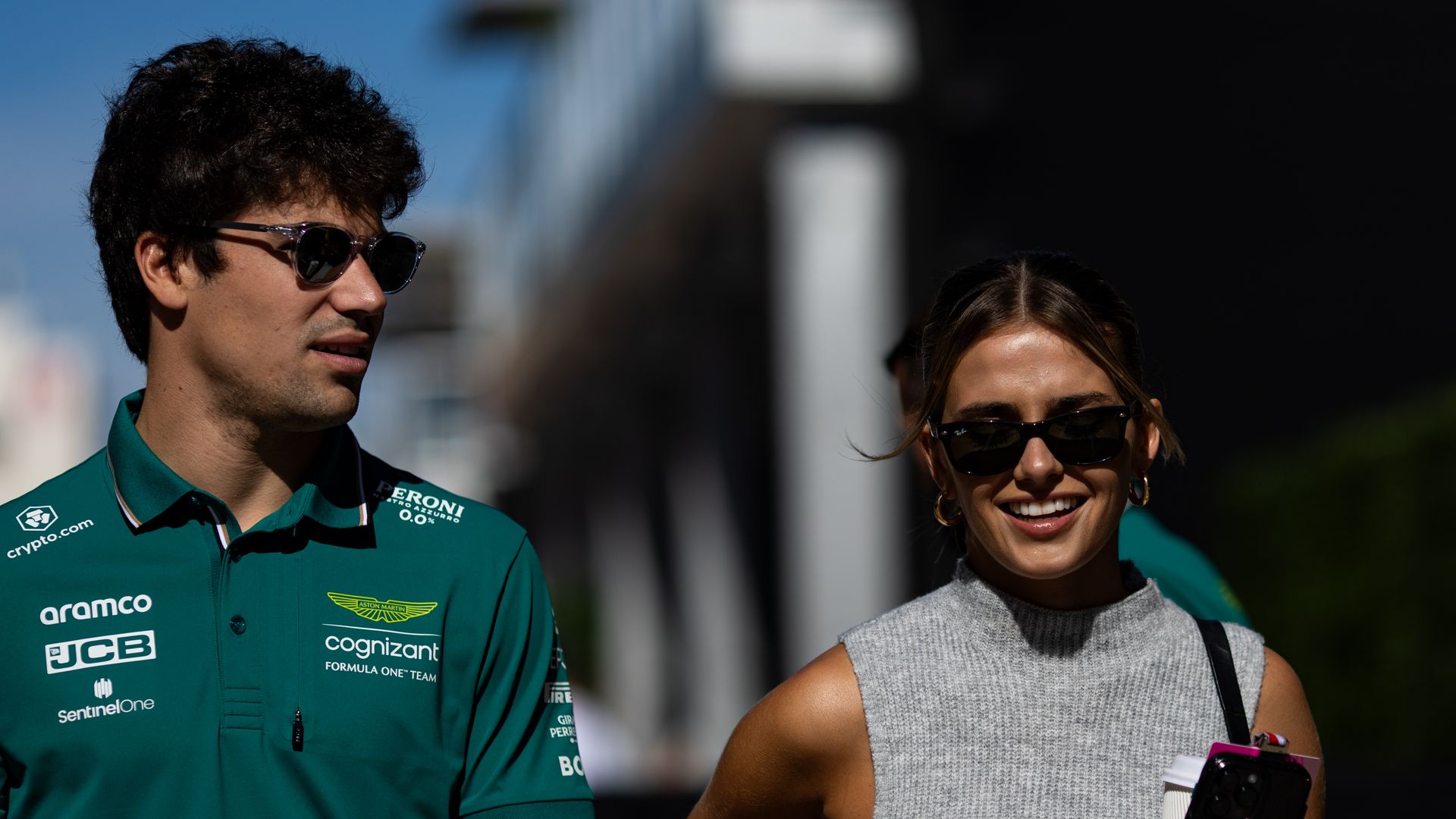 Lance Stroll walking with Marilou Belanger in an F1 paddock