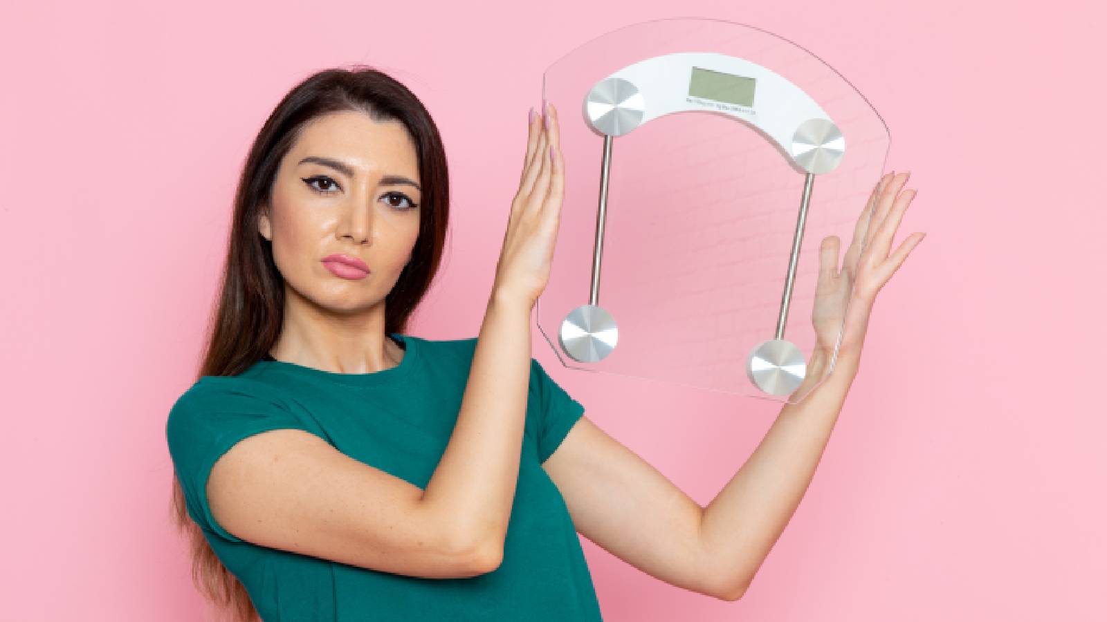 A woman holding a weighing scale