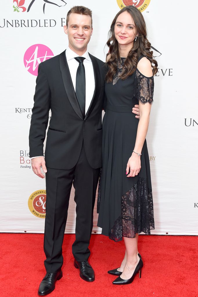 Jesse Spencer in a black suit and Kali Woodruff in a black lace dress with curled hair