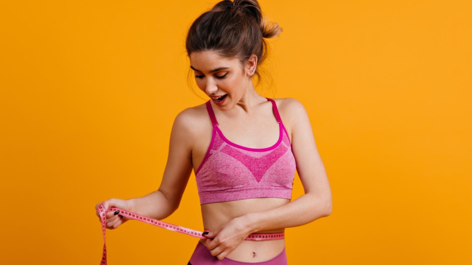 A woman taking measurements of her waist 