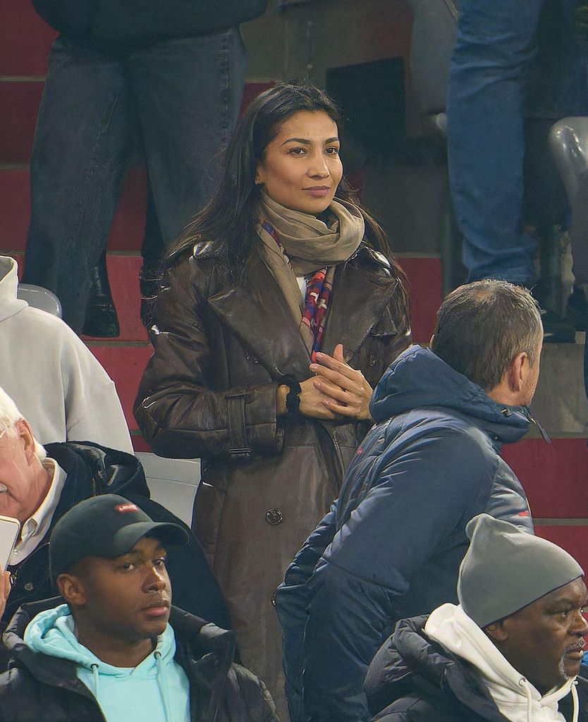 Natalie Max in a brown coat in a football crowd