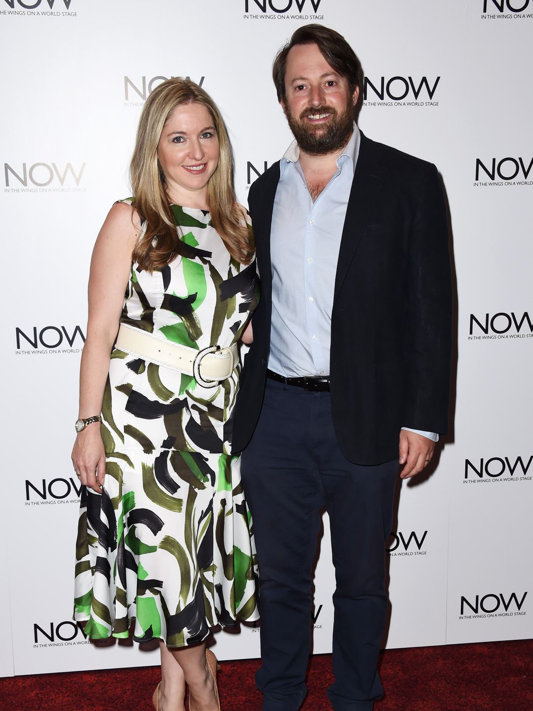 couple smiling on red carpet 