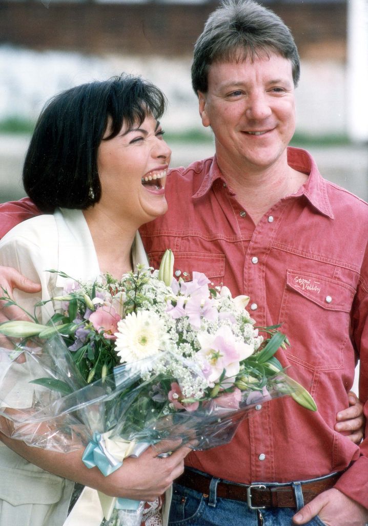 Lorraine Kelly in a white jacket laughing at her husband Steve Smith