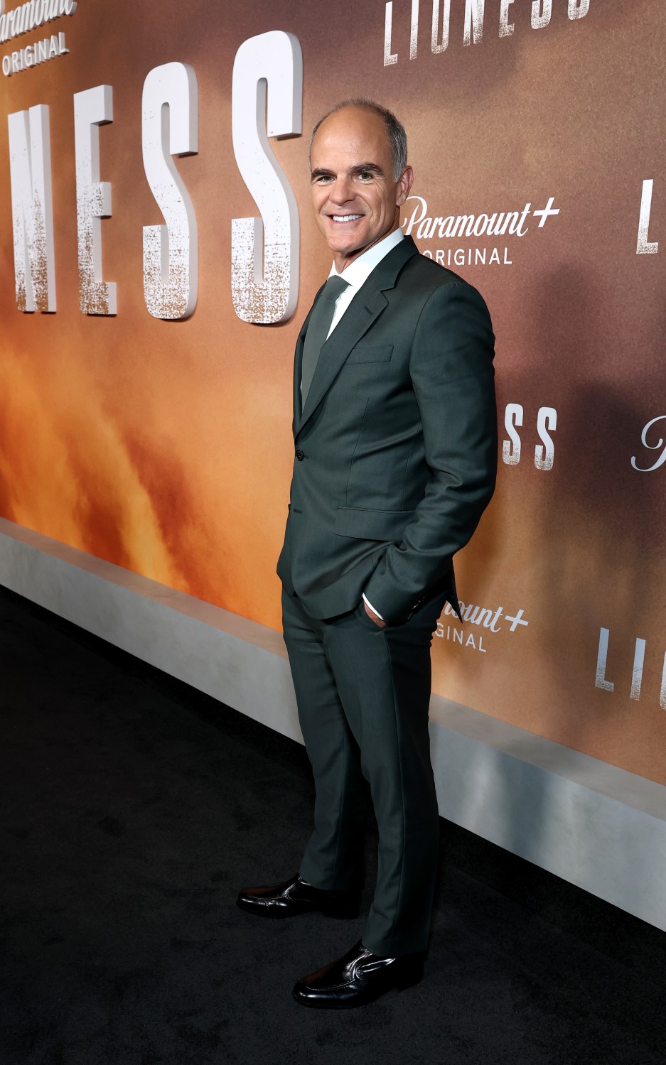 Michael Kelly poses in a dark suit at the Lioness premiere