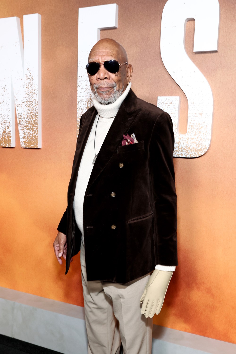 Morgan Freeman attends the Lioness premiere and poses in a pair of sunglasses and brown velvet blazer