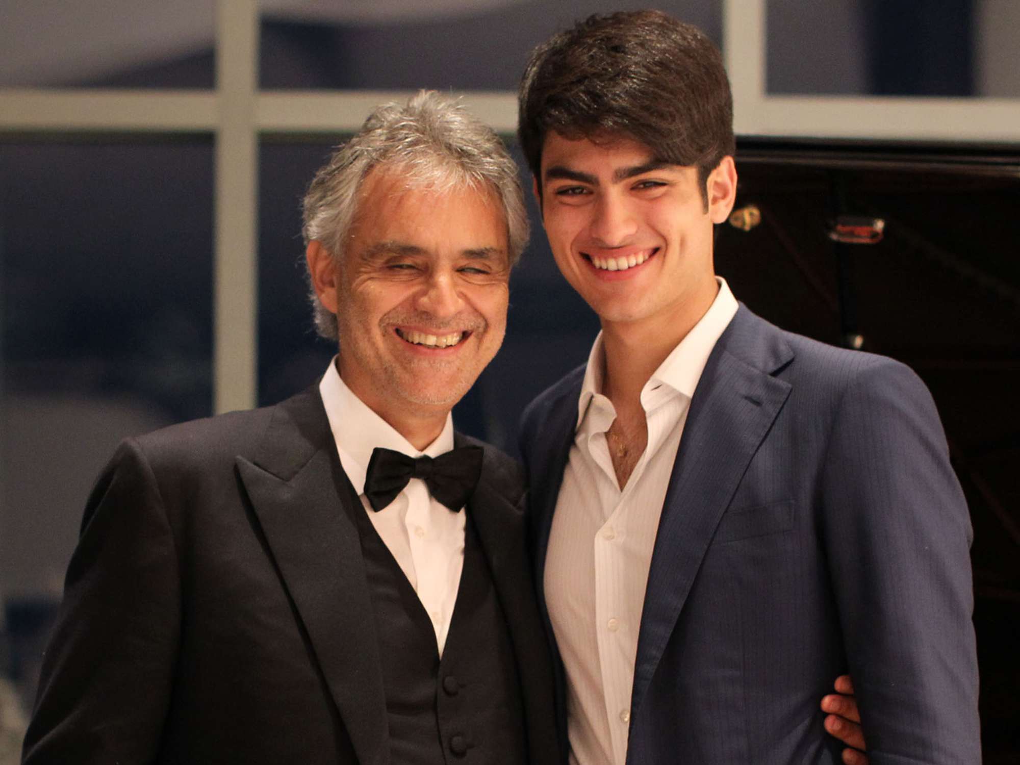 Andrea Bocelli and son Matteo Bocelli break away from the guests for a moment together at the piano during Alfred Mann Foundation's an Evening Under The Stars with Andrea Bocelli on June 8, 2015