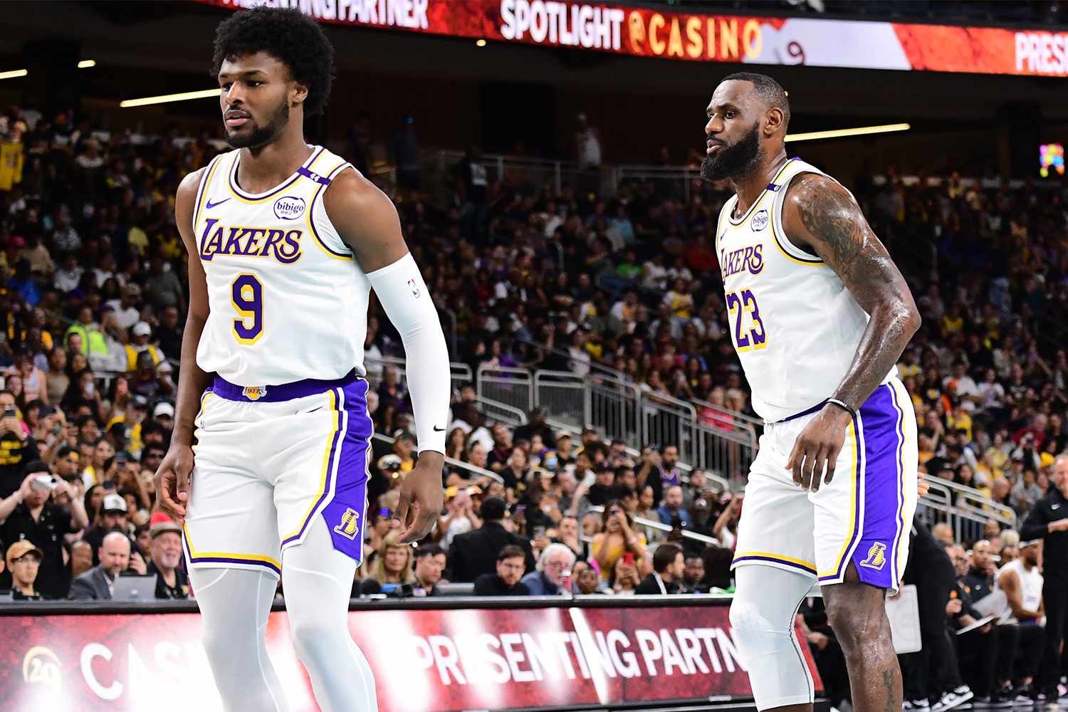 Bronny James #9 and LeBron James #23 of the Los Angeles Lakers look on during the game against the Phoenix Suns on October 6, 2024 at Acrisure Arena in Palm Springs, California.