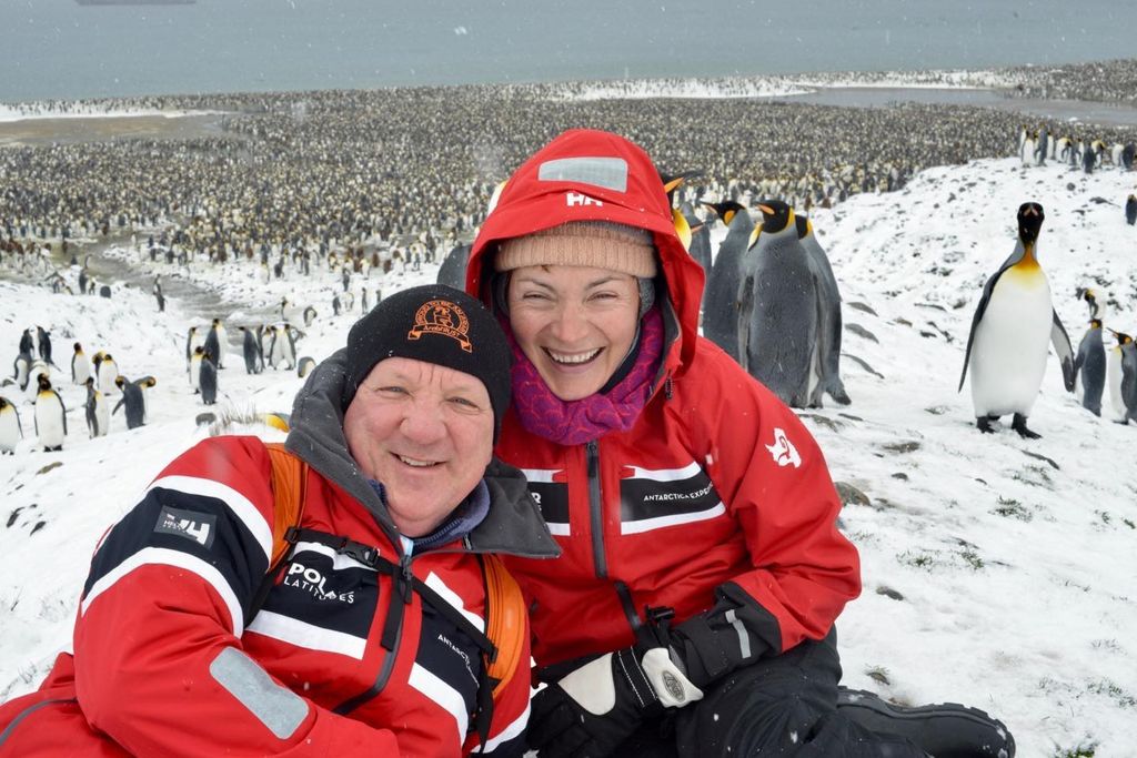 couple posing with penguins