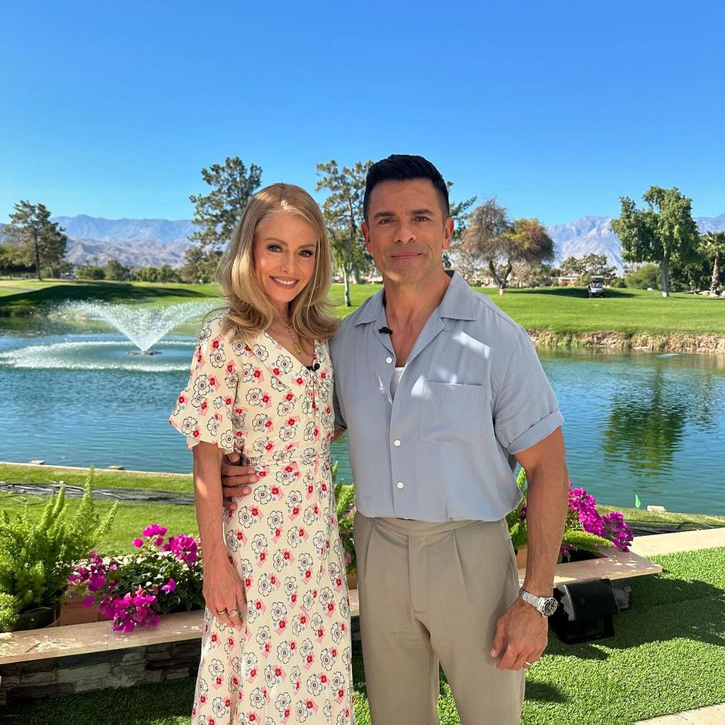 Kelly Ripa and Mark Consuelos posing on a golf course in CAlifornia