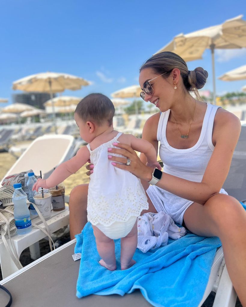 mother with baby daughter at beach