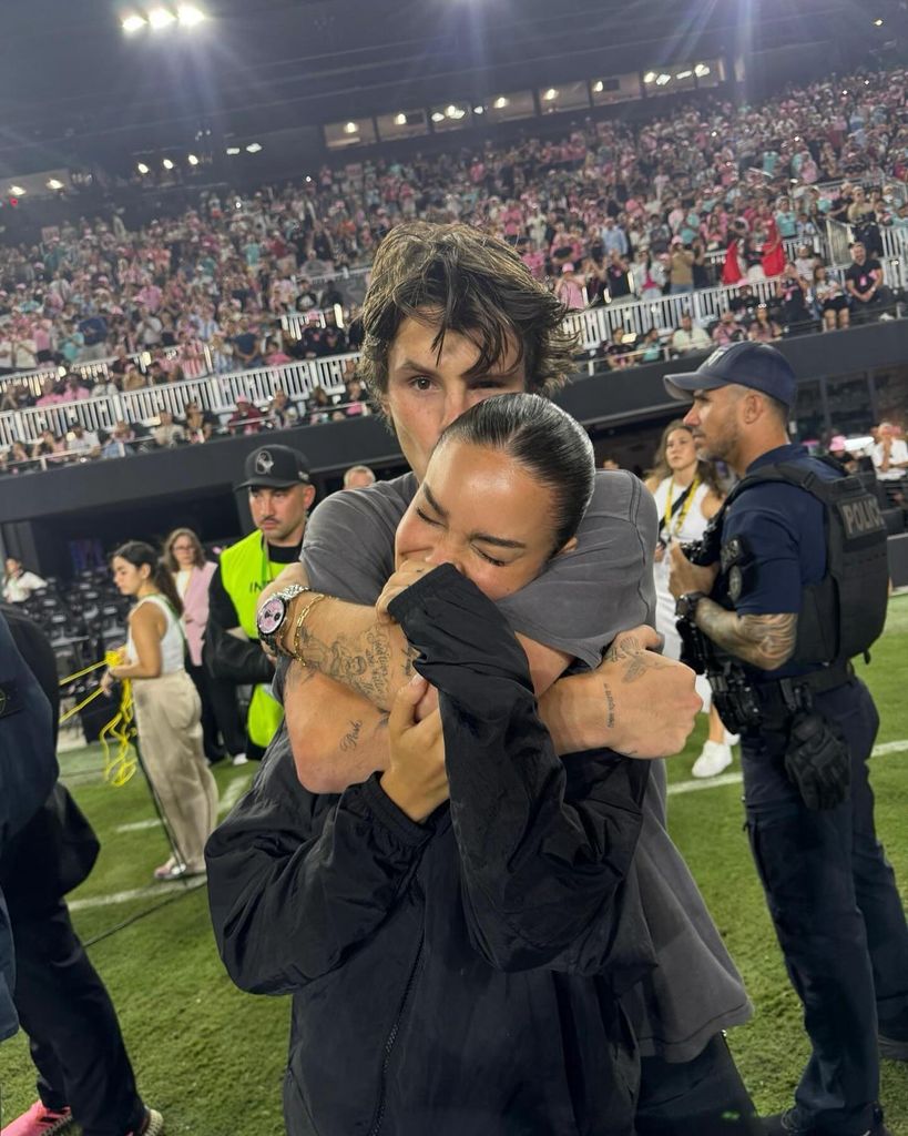 couple sharing hug on football pitch