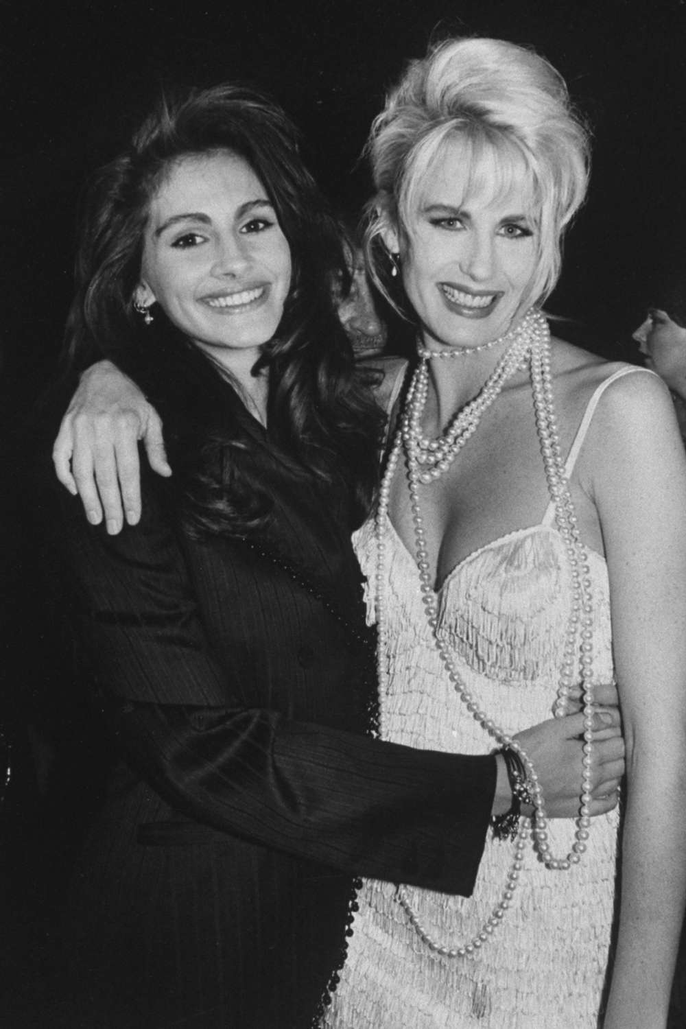 Actress Daryl Hannah with her arm around co-star Julia Roberts at the premiere of the motion picture Steel Magnolias