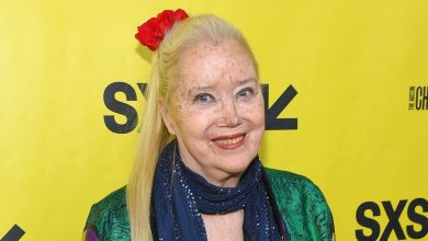 Sally Kirland poses against a yellow backdrop.