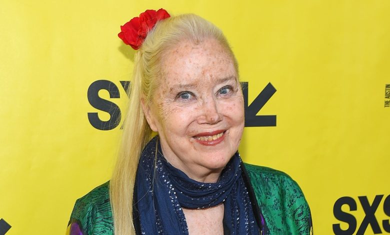 Sally Kirland poses against a yellow backdrop.