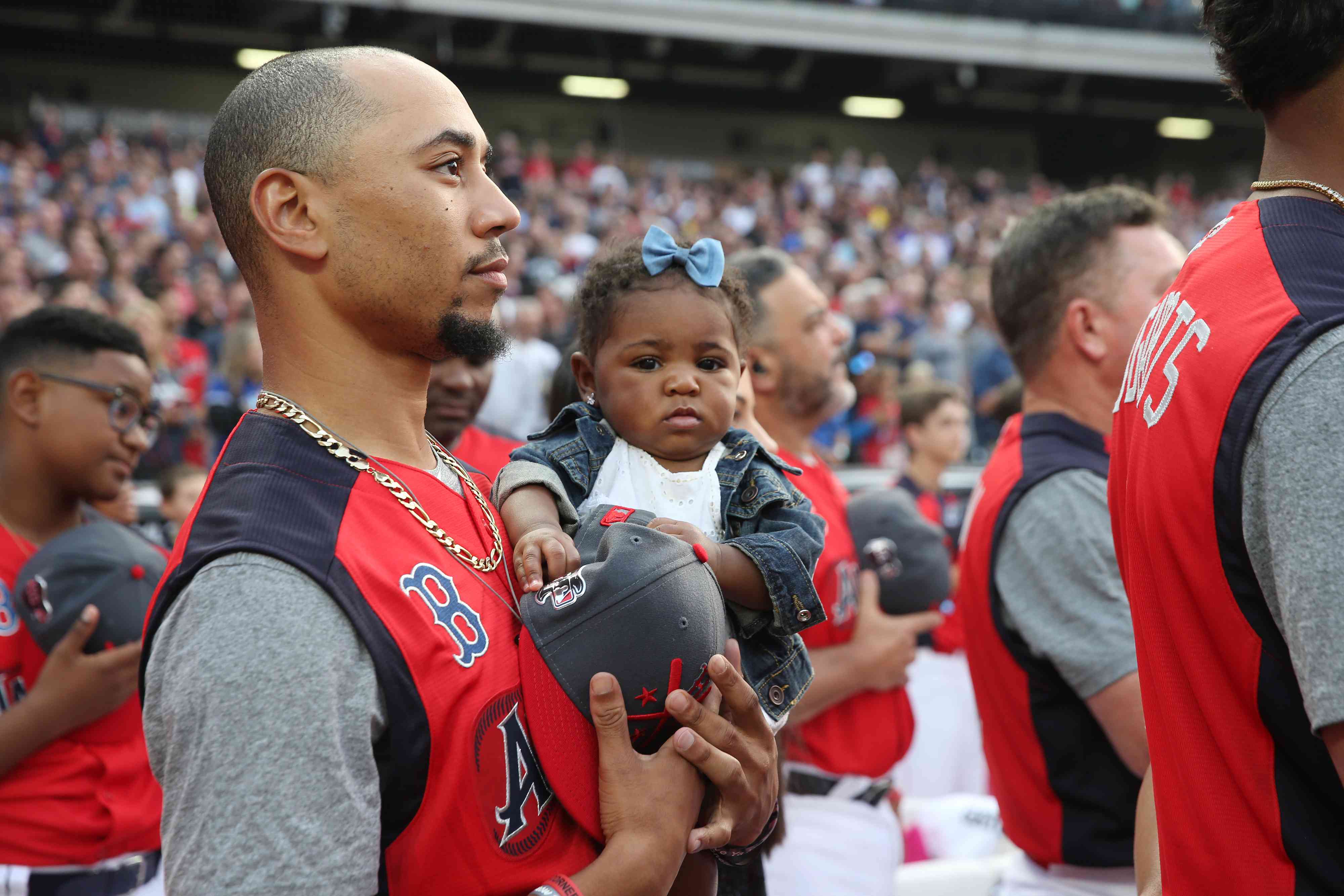 Mookie Betts #50 of the Boston Red Sox holds his daughter during the T-Mobile Home Run Derby at Progressive Field on Monday, July 8, 2019 in Cleveland, Ohio.