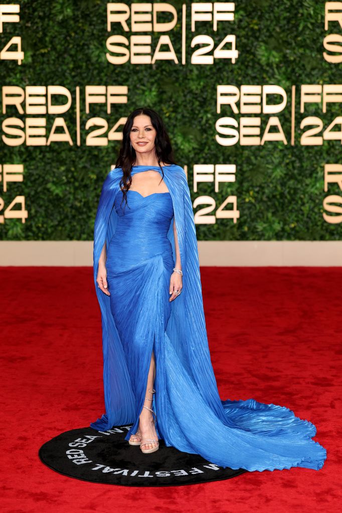 Catherine Zeta-Jones on red carpet in blue caped gown