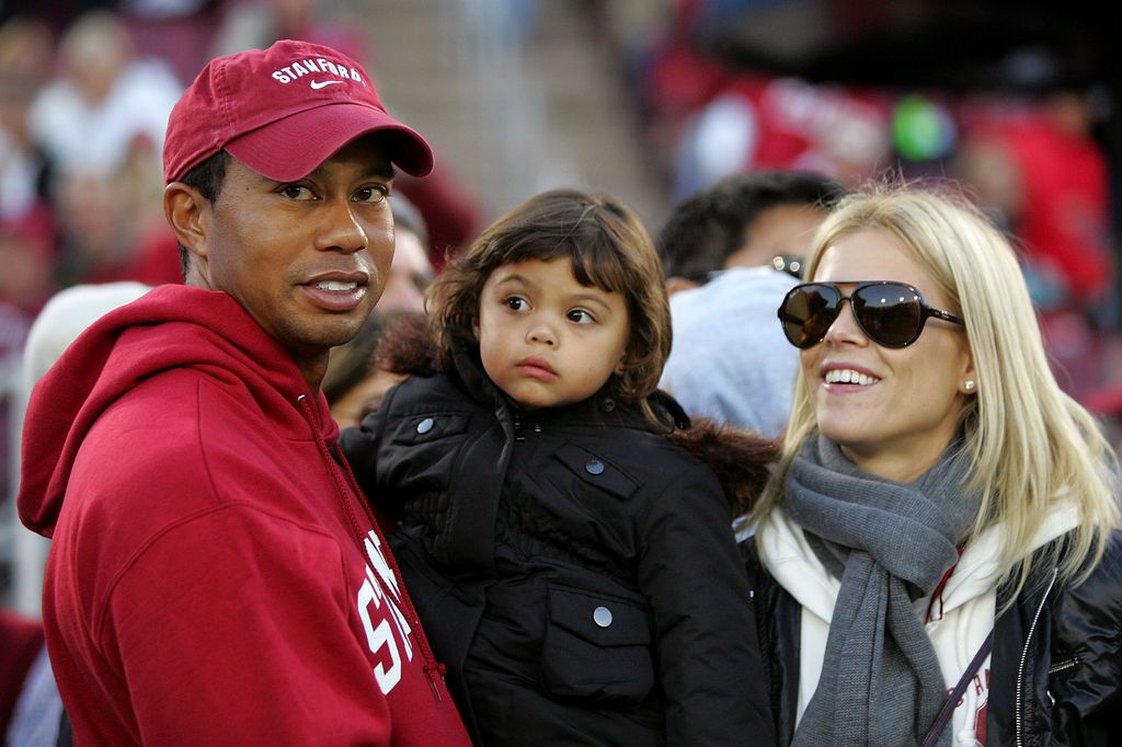 Tiger Woods holds his daugher, Sam, and stands next to his wife, Elin Nordegren, on the sidelines before the Cardinal game against the California Bears at Stanford Stadium on November 21, 2009 in Palo Alto, California