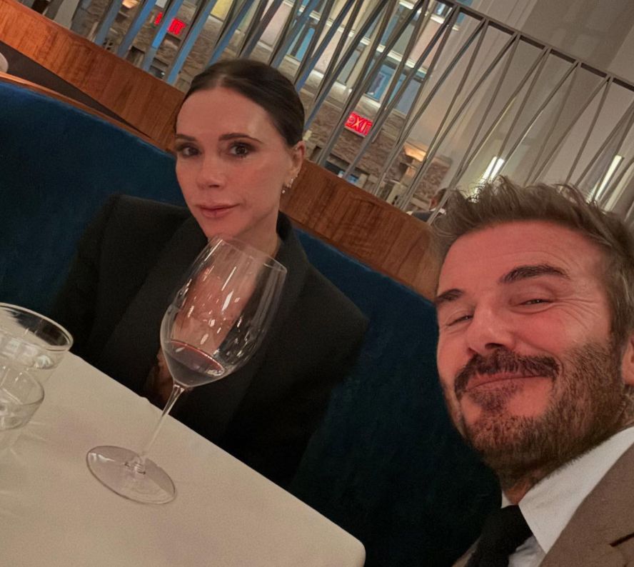 David Beckham and Victoria Beckham taking a selfie at a restaurant