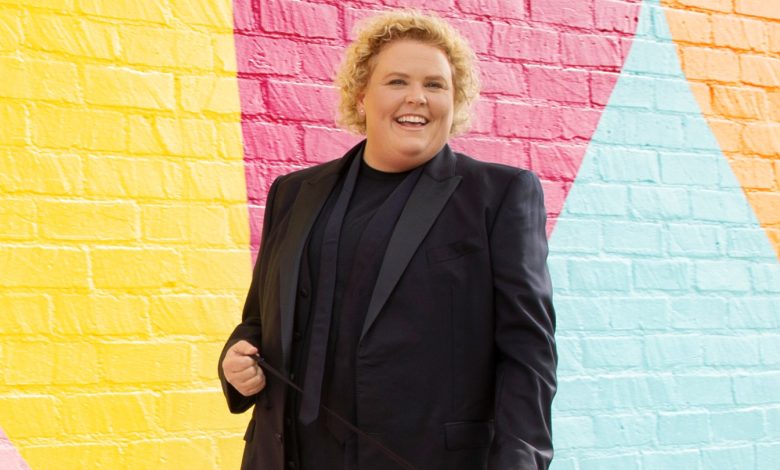 Fortune Feimster poses against a colorful backdrop.