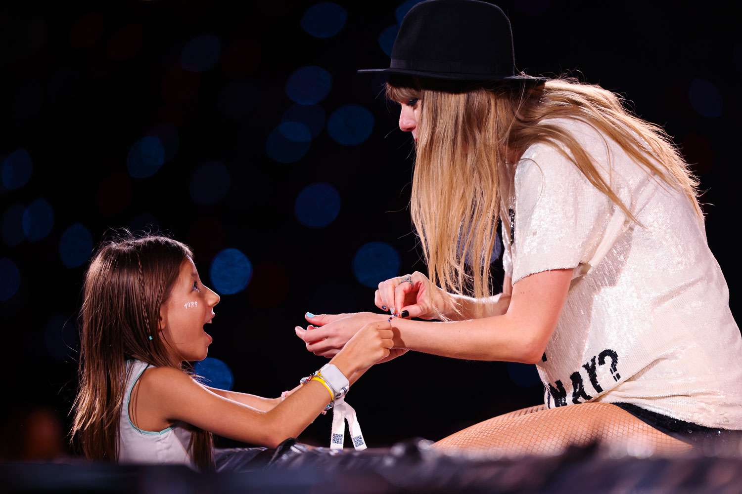 A young fan exchanges friendship bracelets with Taylor Swift as she performs onstage during "Taylor Swift | The Eras Tour" at Allianz Parque on November 24, 2023 in Sao Paulo, Brazil. 