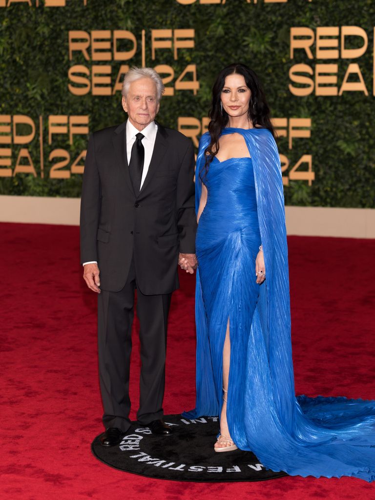 Michael Douglas and Catherine Zeta-Jones in blue dress on red carpet 