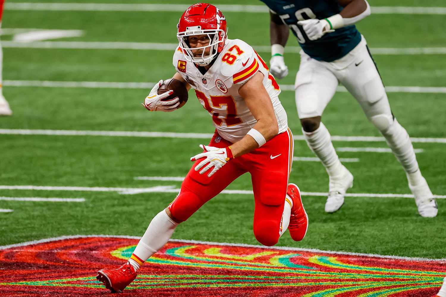 Travis Kelce #87 of the Kansas City Chiefs runs with the ball after a catch during Super Bowl LIX