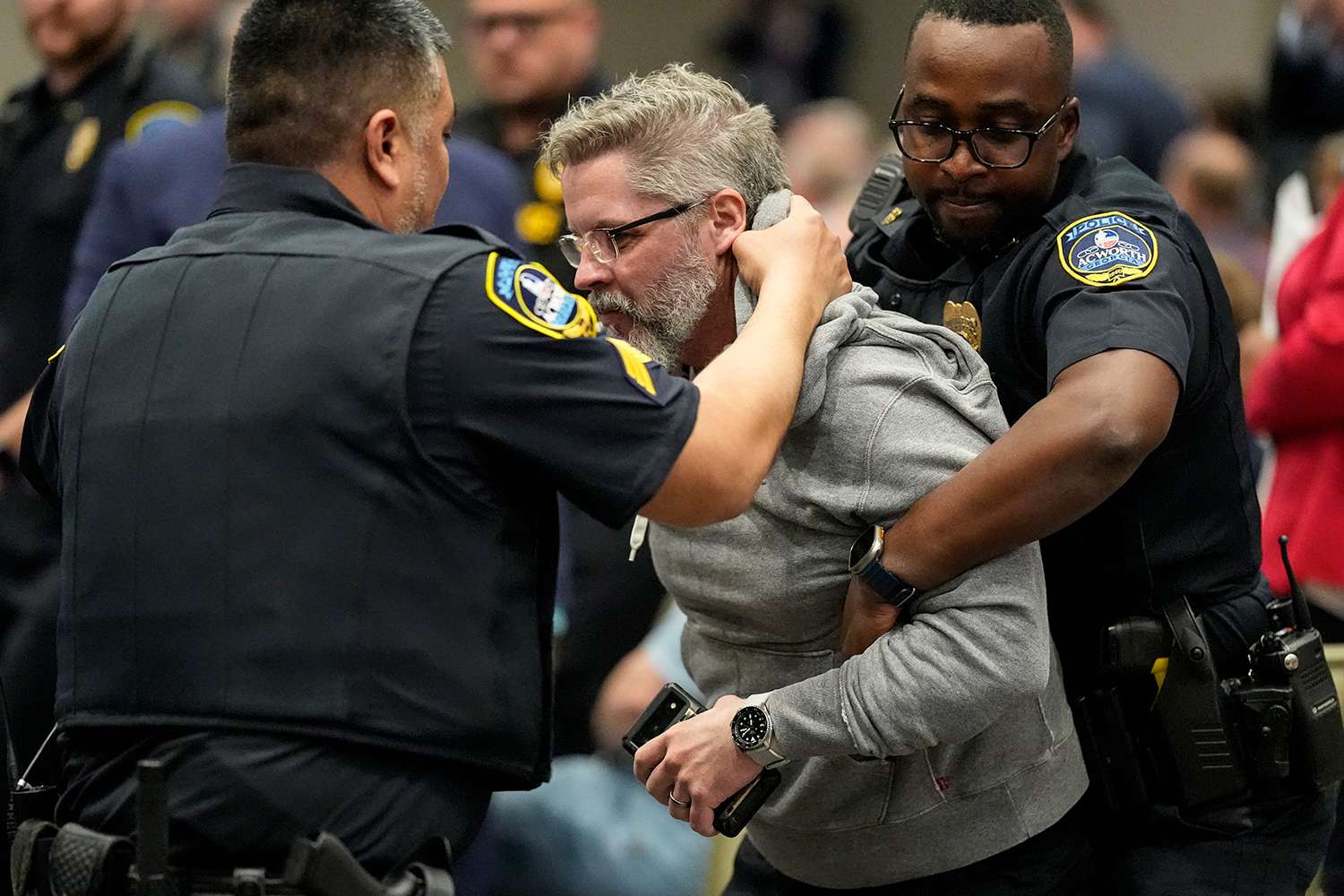 A protester is removed as Rep. Marjorie Taylor Greene, R-Ga., speaks during a town-hall style meeting