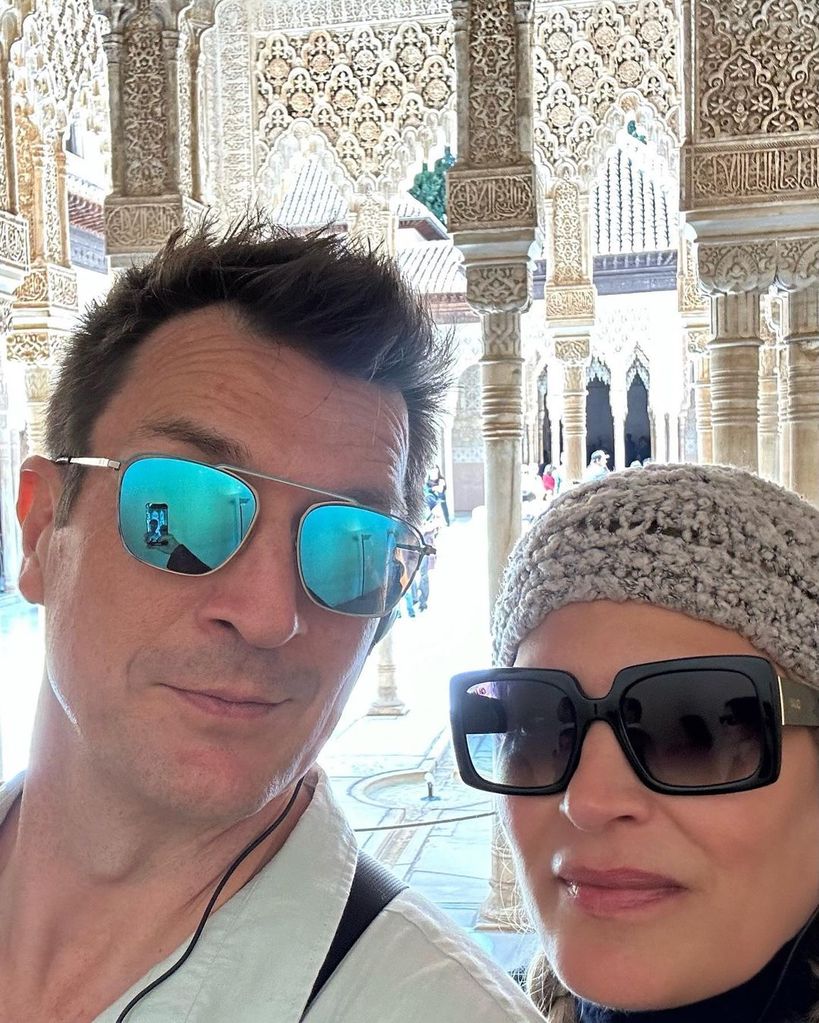 Nathan Fillion and Michelle Chapman  wearing sunglasses on vacation