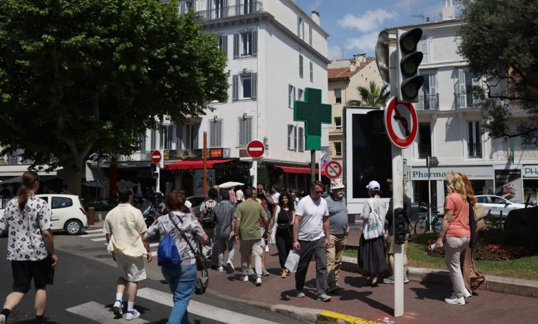 Pedestrians in Cannes cross a street as traffic lights no longer function following Saturday