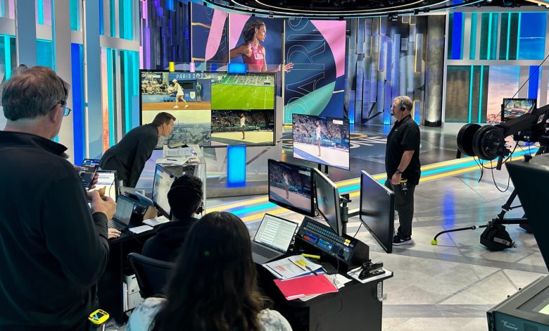 Scott Hanson watches Simone Biles compete in the women