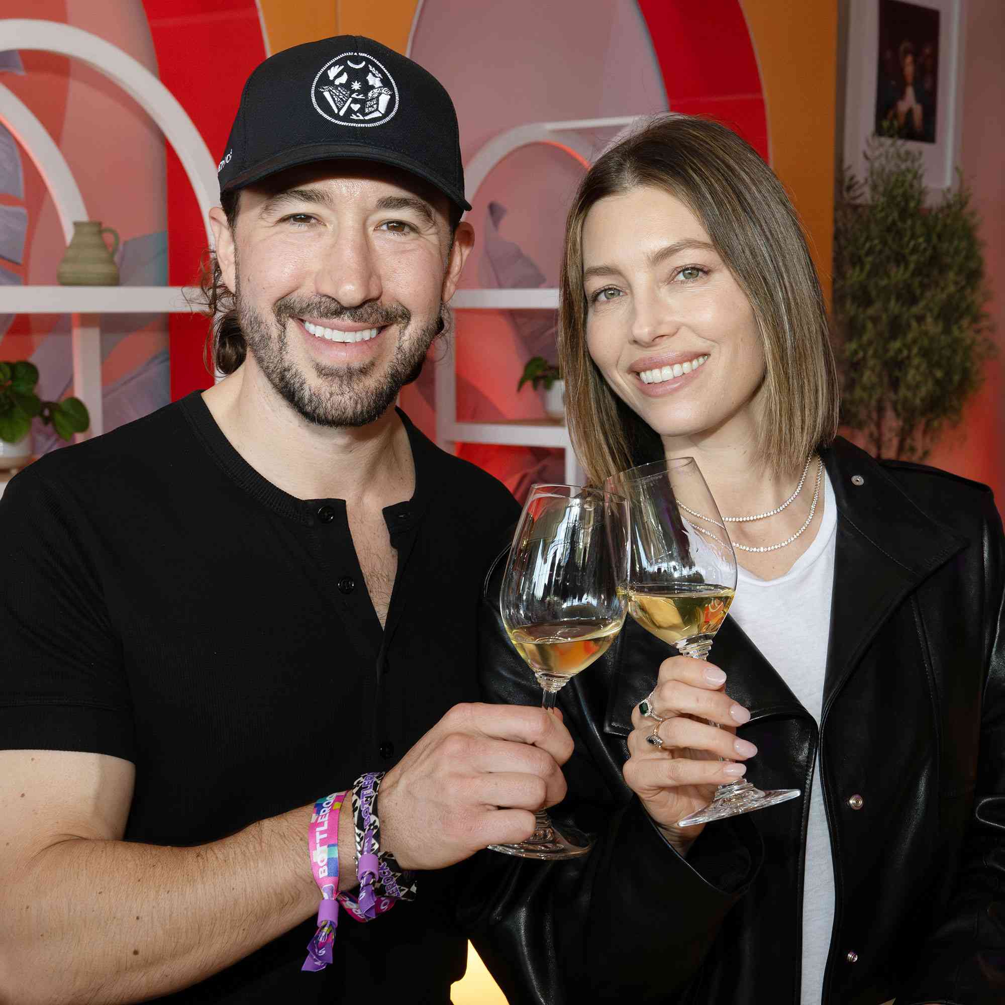 Jessica Biel and person toasting with wine glasses