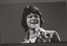 Johnny Rodriguez singing with a microphone