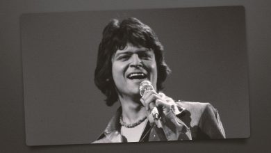 Johnny Rodriguez singing with a microphone
