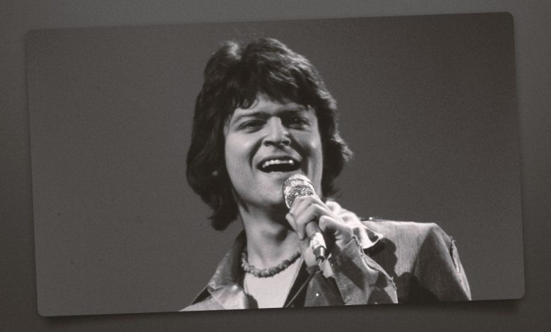 Johnny Rodriguez singing with a microphone