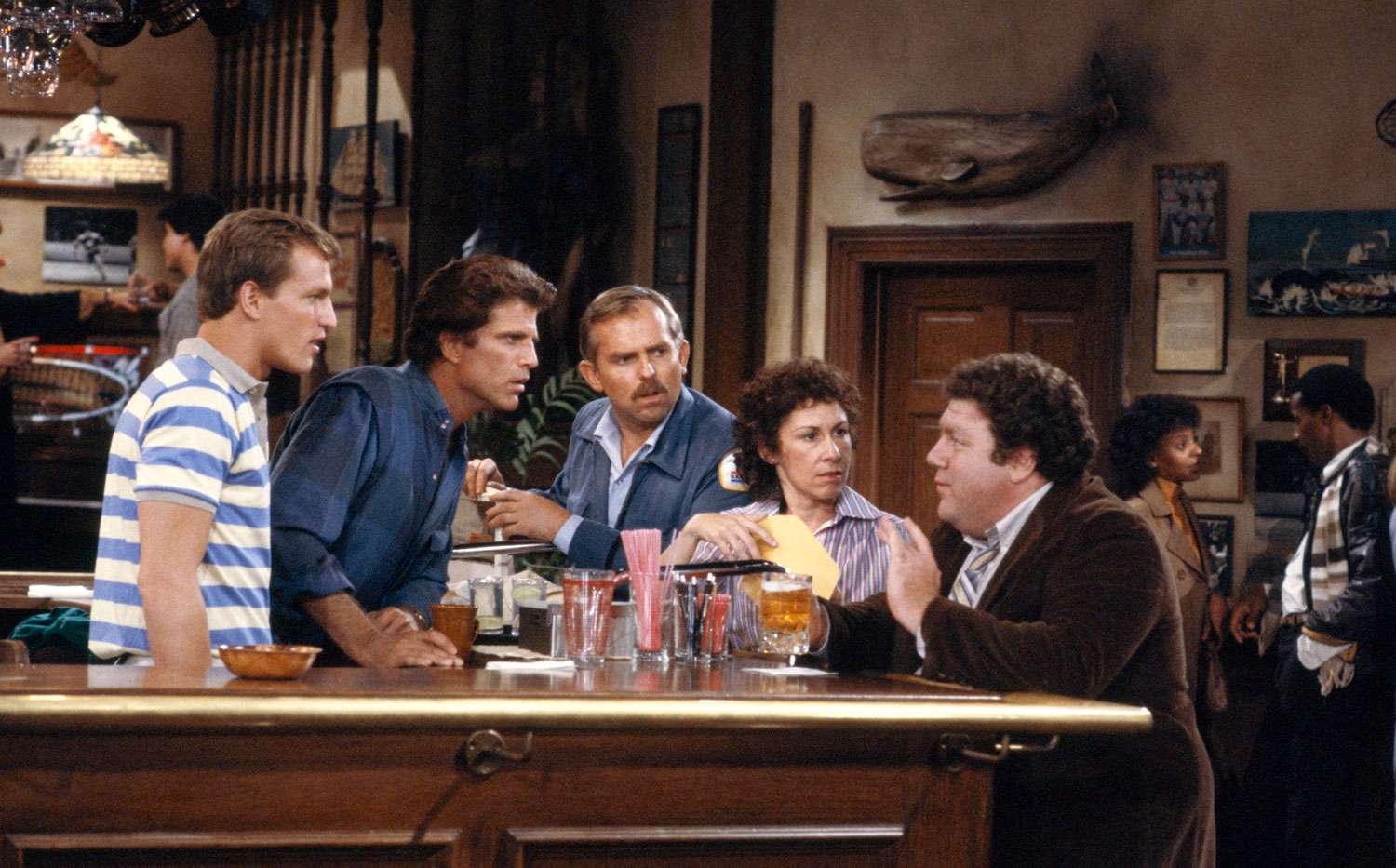 CHEERS -- "Someday My Prince Will Come" Episode 3 -- Aired 10/17/85 -- Pictured: (l-r) Woody Harrelson as Woody Boyd, Ted Danson as Sam Malone, John Ratzenberger as Cliff Clavin, Rhea Perlman as Carla Tortelli, George Wendt as Norm Peterson