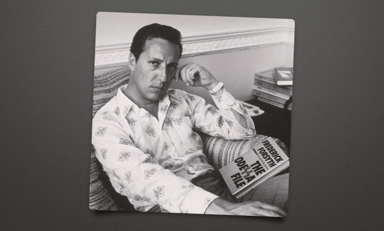 Frederick Forsyth posing for a photo with a book