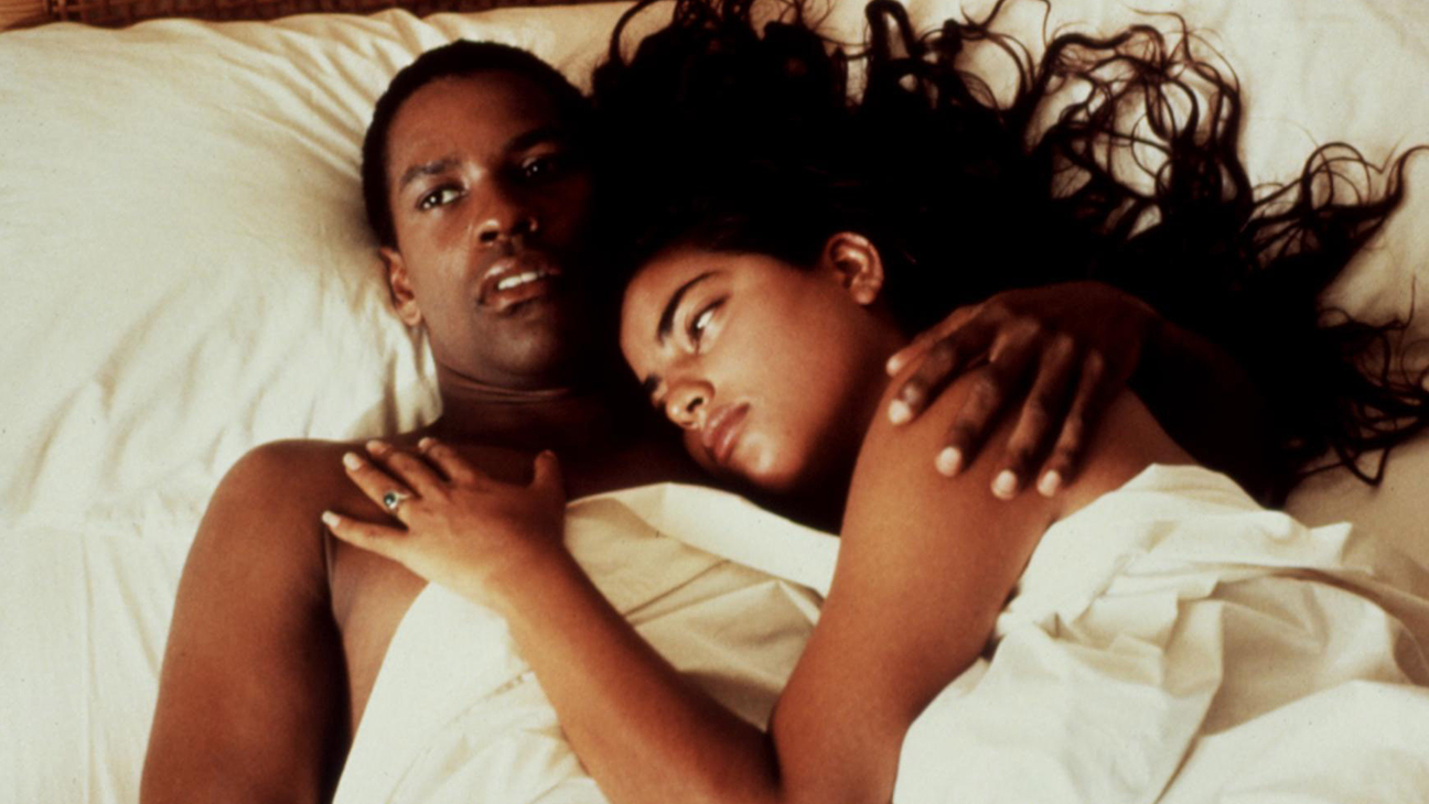 still from the 1991 film Mississippi Masala showing Sarita Choudhury in Denzel Washington's arms laying down