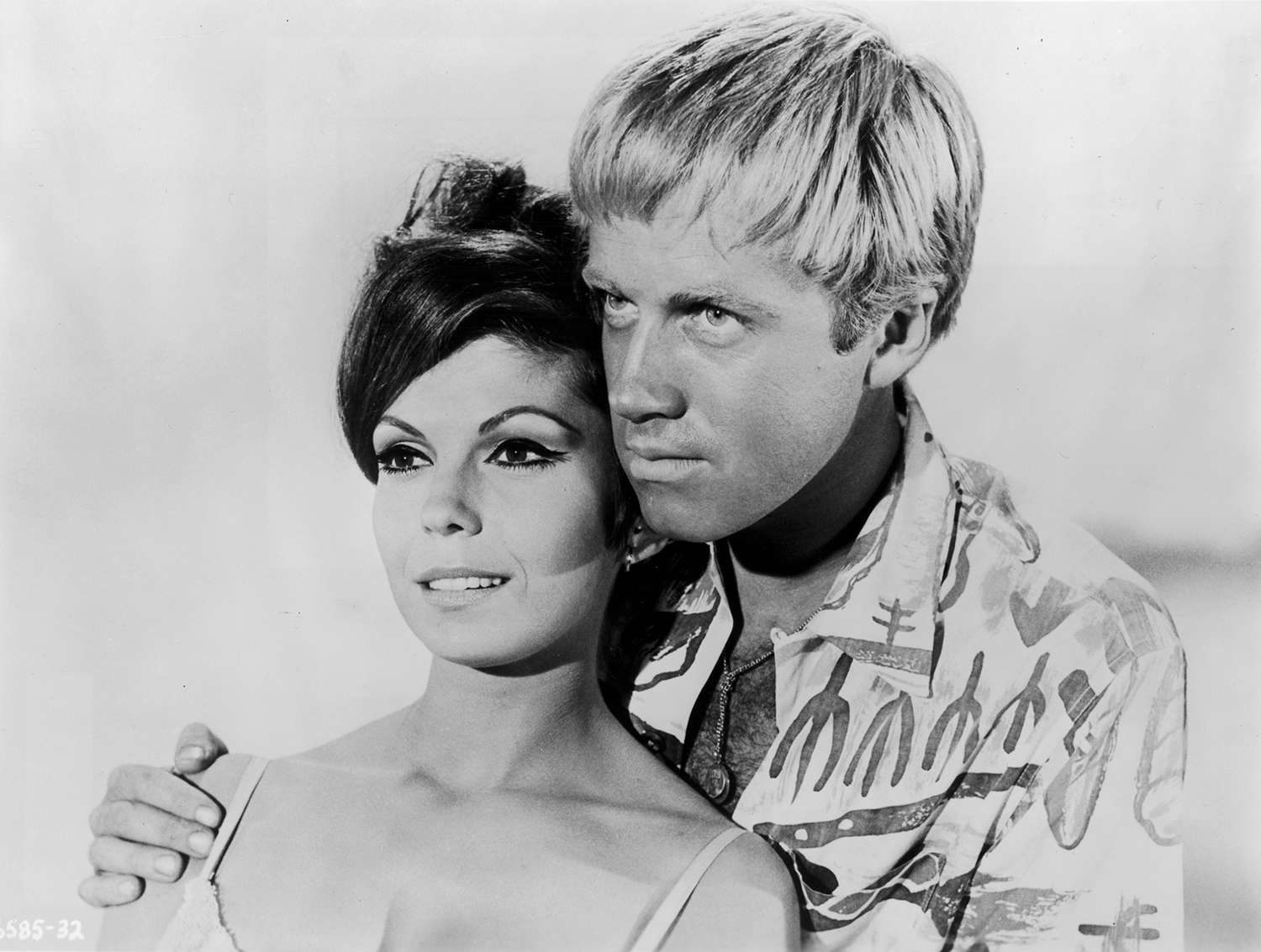 American singer Nancy Sinatra smiles while leaning back against actor Aron Kincaid in a still from director Don Weis's film, 'The Ghost in the Invisible Bikini'. 