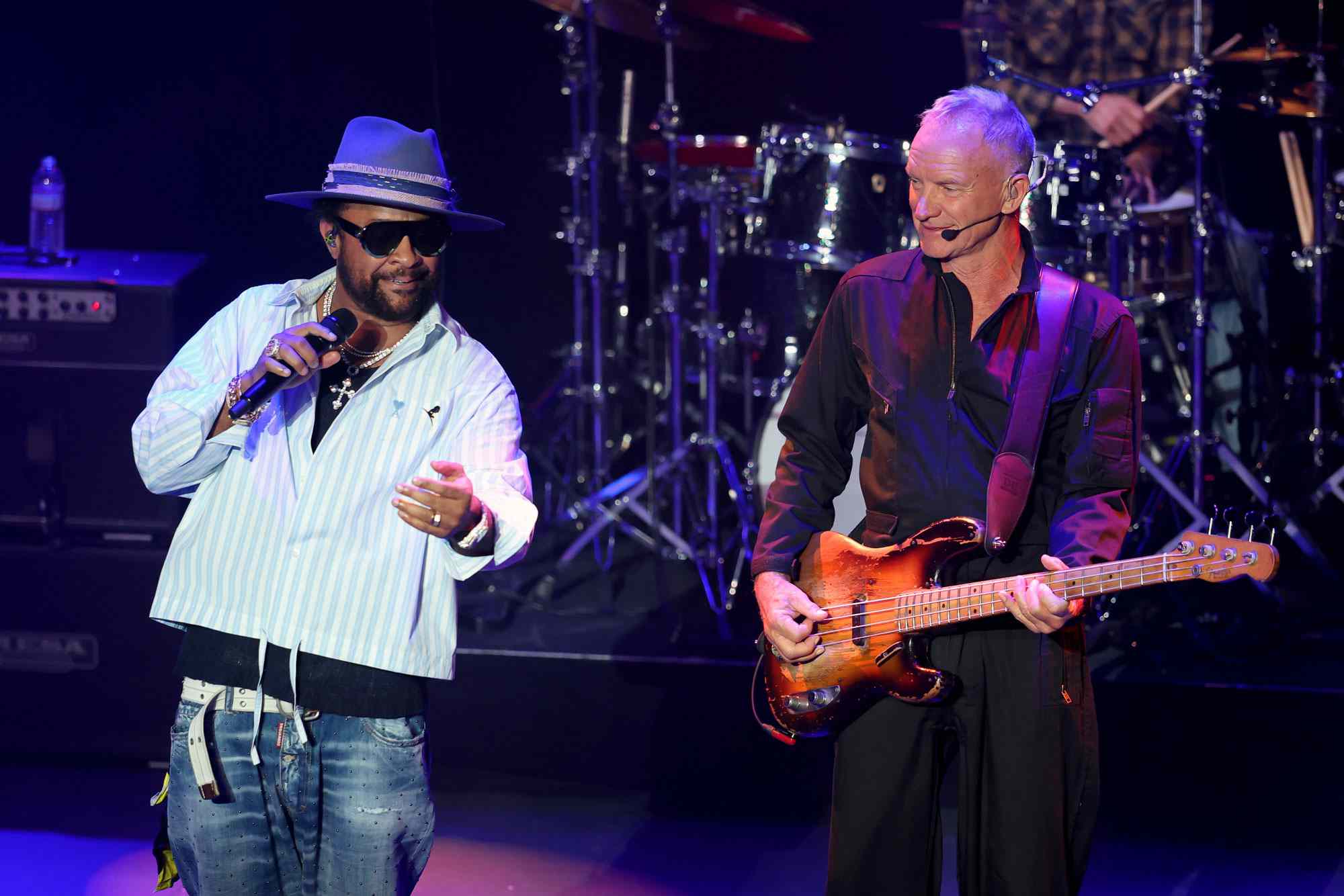 Shaggy singing and Sting playing guitar on stage