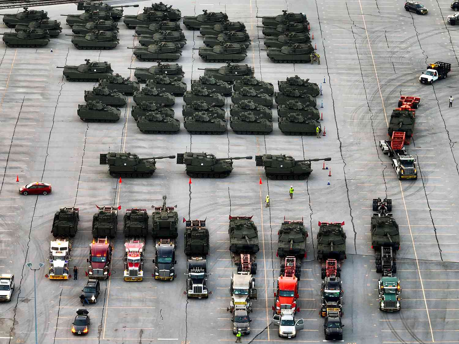 In an aerial view, U.S. Army vehicles, including M1 Abrams tanks, Bradley FIghting Vehicles and M109 howitzers, are are loaded onto tractor trailer trucks in the CSX rail yard on June 09, 2025 in Jessup, Maryland.