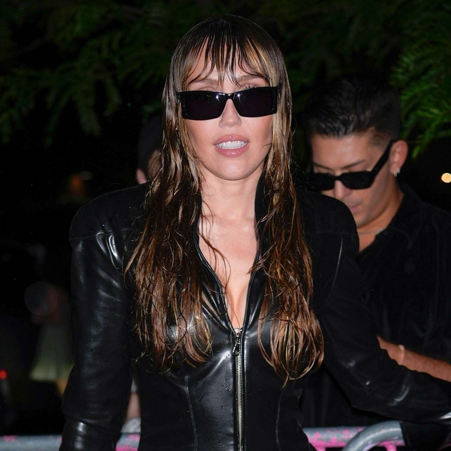 Miley Cyrus made a fierce entrance at her album listening party at 3 Dollar Bill in Brooklyn, rocking a black leather mini dress, sheer tights, and wet-look hair. 