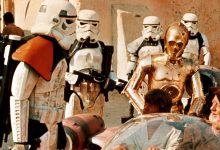 Stormtroopers question Luke Skywalker (Mark Hamill) and Obi-Wan Kenobi (Alec Guinness) on Tatooine in 1977