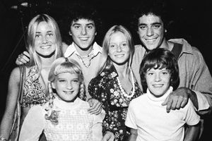 Young cast members of the television series, 'The Brady Bunch' pose with a cake celebrating the show's 100th episode, circa 1973. (L-R): Maureen McCormick, Susan Olsen, Christopher Knight, Eve Plumb, Barry Williams and Mike Lookinland