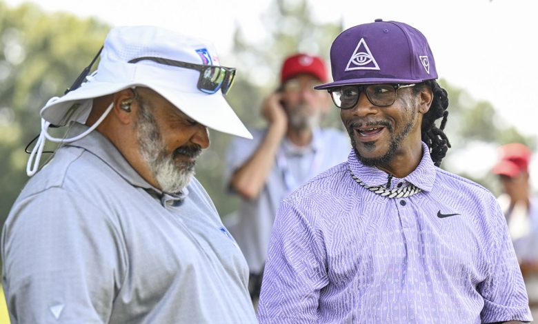 Comedian Micah Katt Williams laughs with PGA TOUR LIVE analyst Michael Collins during the first round of the TOUR Championship, the final event of the FedExCup Playoffs, at East Lake Golf Club on August 29, 2024 in Atlanta, Georgia.