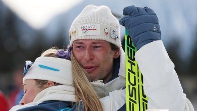 Bronze medalist Sturla Holm Laegreid of Team Norway is embraced by Ingrid Landmark Tandrevold of Team Norway after the medal ceremony for the Men
