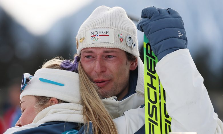 Bronze medalist Sturla Holm Laegreid of Team Norway is embraced by Ingrid Landmark Tandrevold of Team Norway after the medal ceremony for the Men